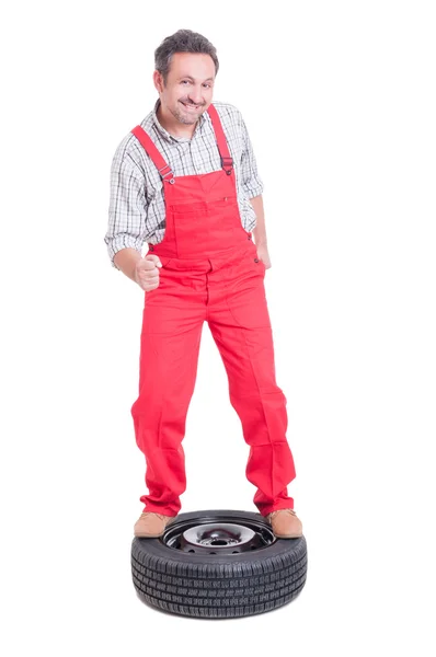 Mechanic dancing on top of a car wheel — Stock Photo, Image