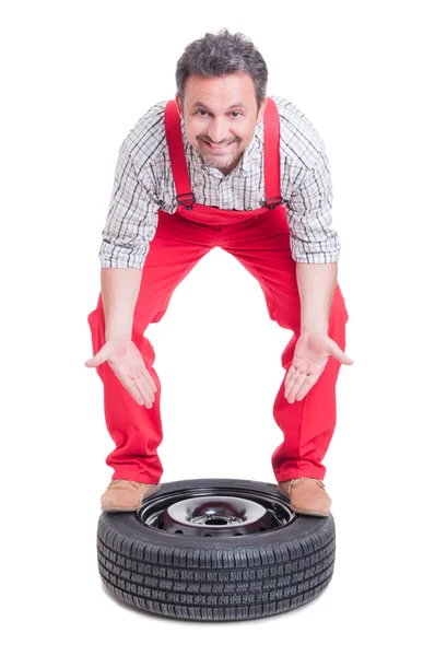 Mecânico apresentando uma nova roda de carro — Fotografia de Stock