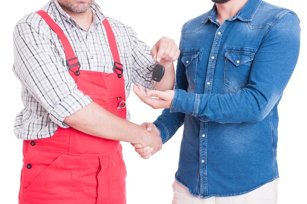 Anonymous mechanic handing car key to customer or client — Stock Photo, Image