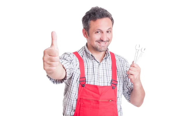 Mechanic holding spanners and showing like gesture — Stock Photo, Image