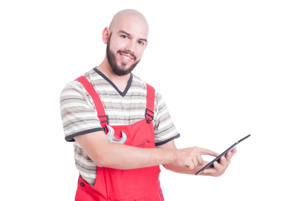 Gelukkig vriendelijke en jonge mechanic met behulp van een draadloze tablet — Stockfoto