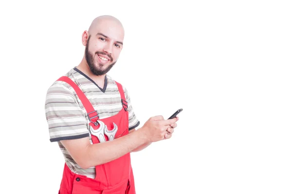 Feliz mecánico charlando en su teléfono inteligente — Foto de Stock