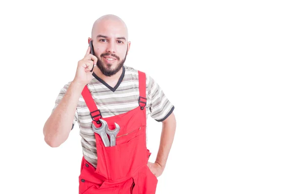 Joven mecánico hablando por teléfono buscando feliz — Foto de Stock