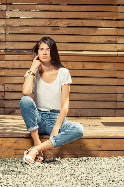 Modelo feminino posando ao ar livre vestindo jeans e t-shirt — Fotografia de Stock