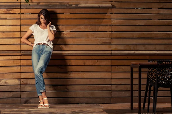 Beautiful hipster woman leaning on wooden fence — Stock Photo, Image