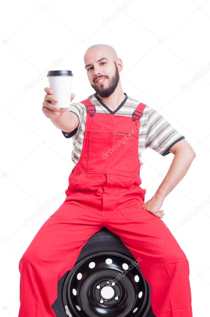 Friendly mechanic offering a cup of coffee to go