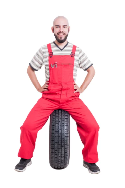 Gelukkig mechanic zittend op auto wielen — Stockfoto