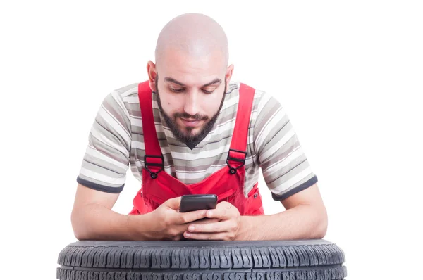 Mecánico tener un descanso y el uso de teléfono inteligente — Foto de Stock