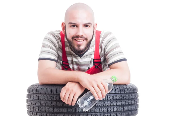 Mecánico sonriente sosteniendo una botella de agua — Foto de Stock