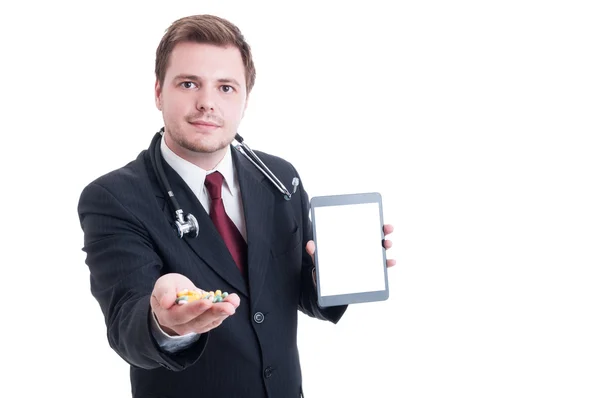 Современный врач держит таблетки и белый пустой экран планшета — стоковое фото
