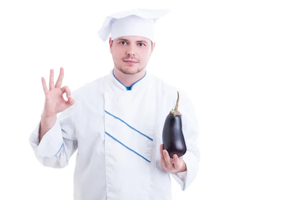 Cocinar sosteniendo berenjena y mostrando como o pulgar hacia arriba — Foto de Stock