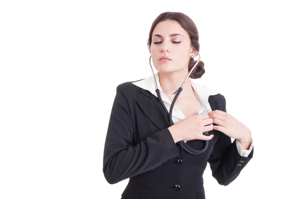 Young female doctor or medic listening her heart with stethoscop — Stock Photo, Image