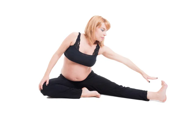 Hermosa joven embarazada estirándose en el suelo —  Fotos de Stock