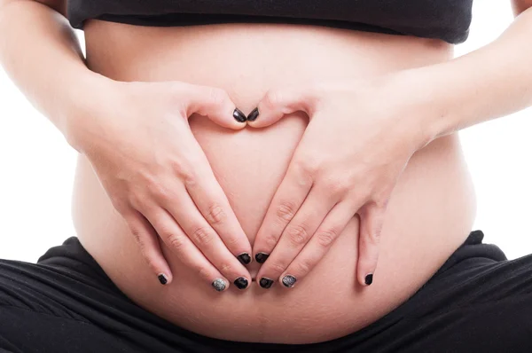 Mulheres grávidas mãos fazendo forma de coração na barriga ou barriga — Fotografia de Stock