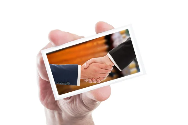 Tangan memegang kartu dengan jabat tangan bisnis atas dinding kayu — Stok Foto
