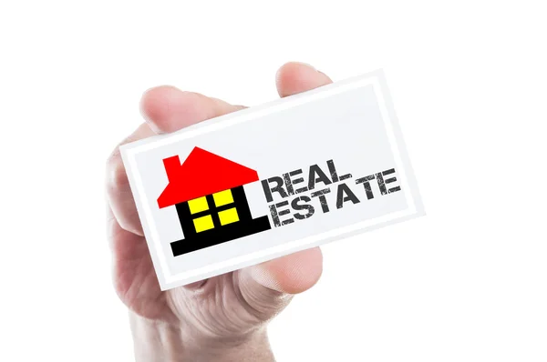 Hand met real estate kaart met huis vorm en tekst — Stockfoto