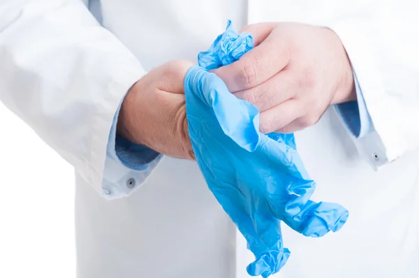 Хирург вытягивает голубые латексные перчатки — стоковое фото
