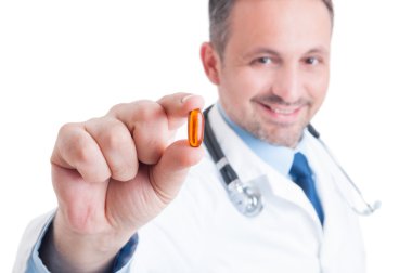 Holding ve balık yağı bir şeffaf hap gösterilen doktor