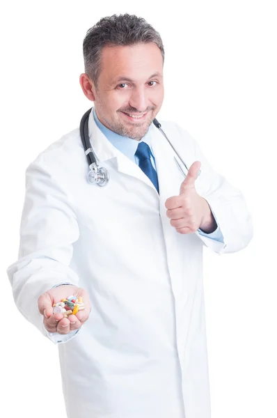 Поощрение врача или медика предлагая руку, полную различных таблеток — стоковое фото