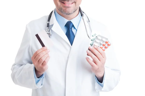 Médico segurando bolhas pílulas e cartão de crédito — Fotografia de Stock