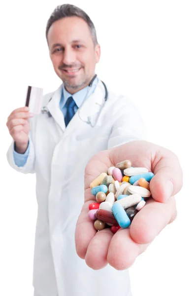 Фармацевт пропонує таблетки і тримає кредитну картку — стокове фото