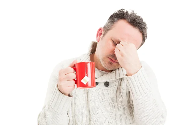 Zieke man Thee beker te houden en het lijden van een migraine — Stockfoto