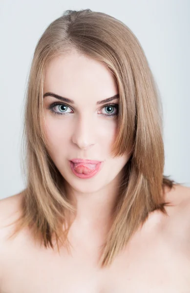 Hermosa mujer modelo sobresaliendo lengua hacia fuera como concepto de cara divertida — Foto de Stock