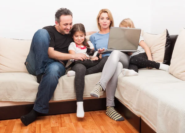 Felice giovane famiglia utilizzando il computer portatile — Foto Stock