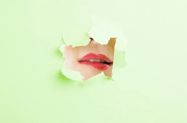 Γυναίκα που δαγκώνει τα χείλη της μέσα από την τρύπα άρπαξαν Πράσινη Βίβλος — Φωτογραφία Αρχείου