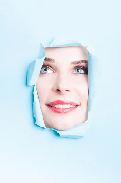 Yırtık karton ile gülümseyen güzel kadın yüz — Stok fotoğraf