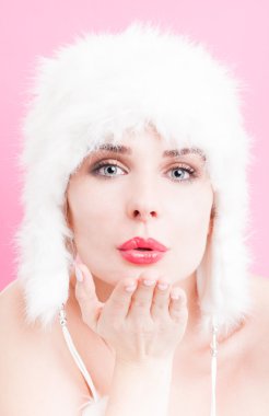 Bir öpücük gönderme ve kürk şapka giymiş seksi kadın