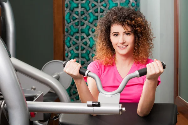 Smiling woman doing biceps exercise
