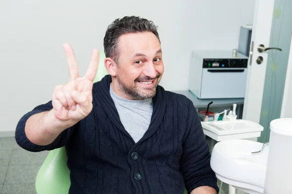 Счастливый пациент сидит доверчиво на стуле стоматолога — стоковое фото
