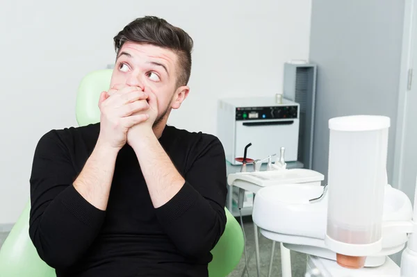 Hombre actuando asustado en silla de dentista — Foto de Stock