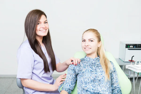 Mulher dentista amigável e paciente feminino relaxado — Fotografia de Stock