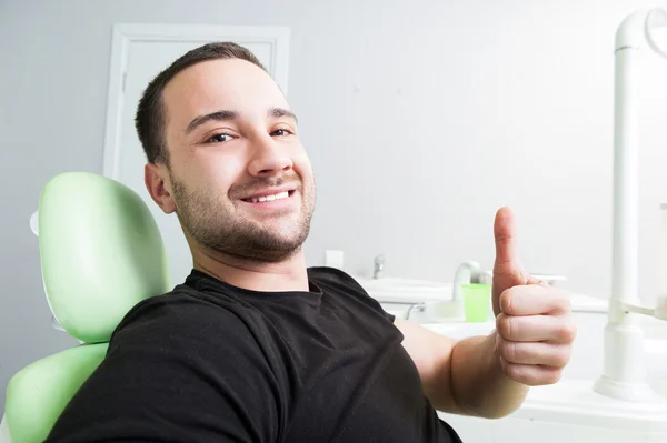 Sonriente paciente masculino en el dentista mostrando como Imagen de stock