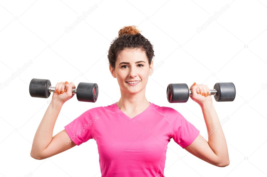 Fit young woman training her deltoids with barbells