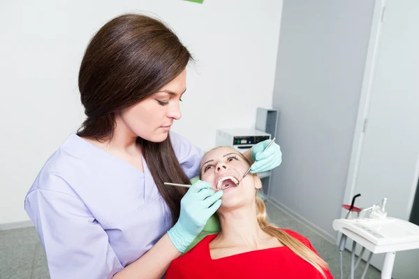 Dentista donna esaminando denti bianchi perfetti o protesi — Foto Stock