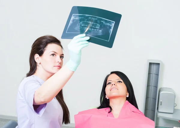 牙科医生给女病人看 x 射线 — 图库照片