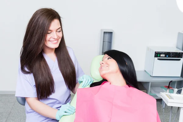 Friendly female dentist showing care for young patient — Stock Photo, Image