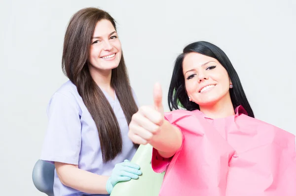 Satisfecho cliente mujer en dentista mostrando como — Foto de Stock