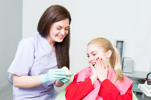 Счастливая и удивленная пациентка у стоматолога — стоковое фото