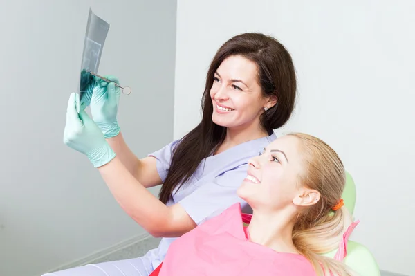 Médico dentista y paciente examinando rayos X dentales —  Fotos de Stock