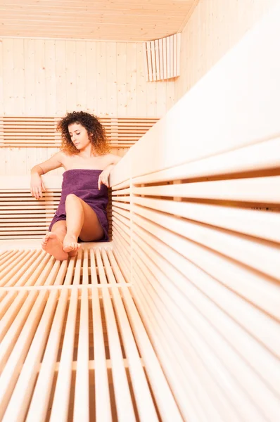 Young curly woman sitting and relaxing in spa resort — Stock Photo, Image