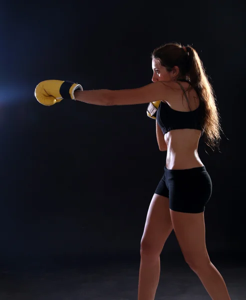 Boxer. Fitness woman wearing yellow boxing gloves over black — Stock Photo, Image