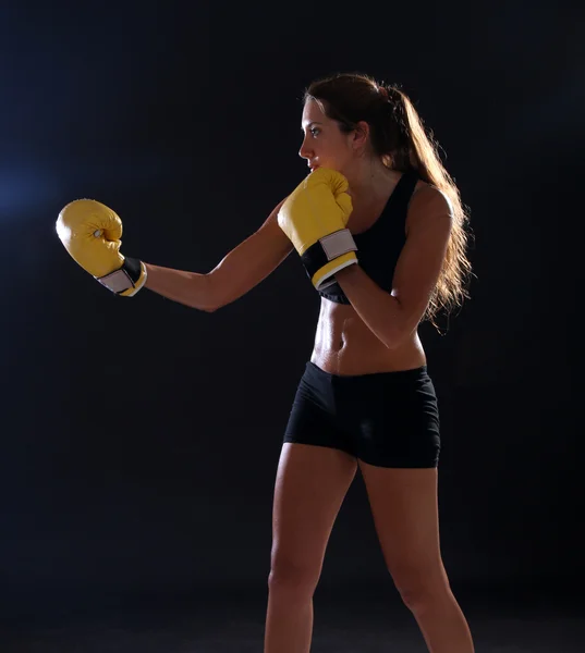 Boxeador. Mujer fitness con guantes de boxeo amarillos sobre negro — Foto de Stock
