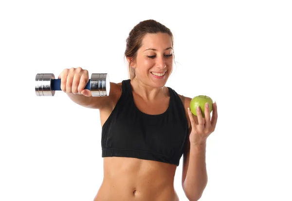 Happy young woman holding a dumbbell and a green apple — Stock Photo, Image