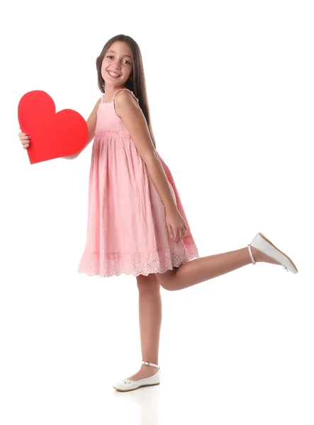 Härlig tjej innehar ett rött hjärta form, över vit bakgrund — Stockfoto