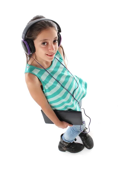 Güzel bir pre-teen kıza bir tablet bilgisayar ve kulaklık kullanarak yüksek açı resim. — Stok fotoğraf