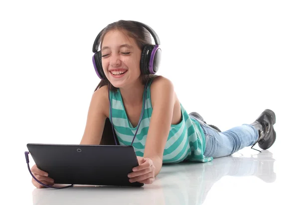 Hermosa chica pre-adolescente en el suelo, utilizando una tableta — Foto de Stock